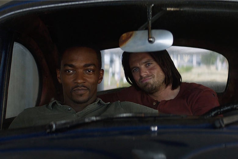 Falcon and Winter Solider sit smiling in a car together.